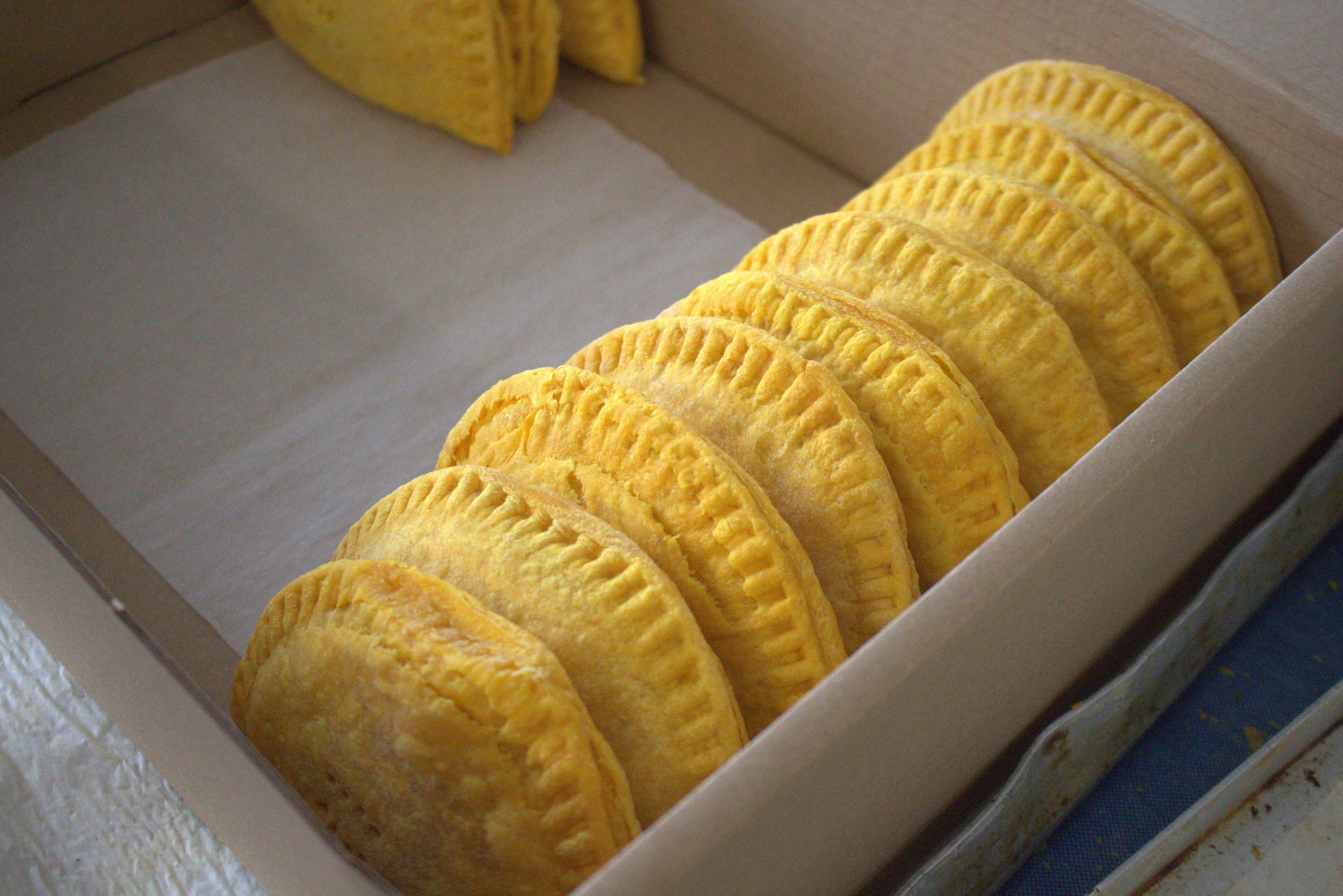 Row of chicken patties in a box on baking paper